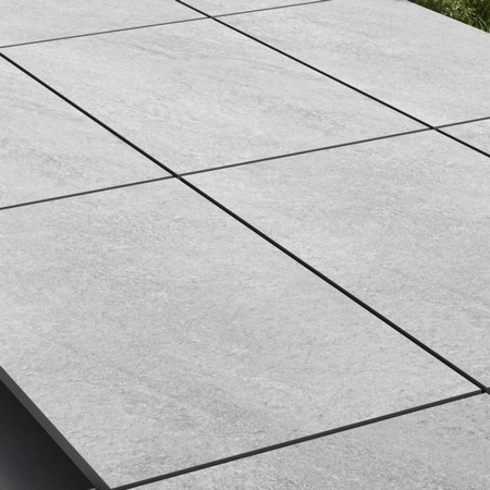 Our Porcelain Paving Hammer Stone Grey is scratch-resistant, hard wearing but also a low maintenance paving. This type of porcelain is also known as vitrified paving, it is mixed light grey shades with subtle white undertones. Porcelain Paving Hammer Stone Grey is also resistant to staining, algae, mould, moss, salts and chemicals. It is maintenance free without the need of sealing. Despite still being hard wearing, long lasting and load resistant, the vitrified porcelain paving range is lighter than traditional paving slabs and is easy to install.   It is made using the mixture of refined natural clays and natural pigments of different colours. 